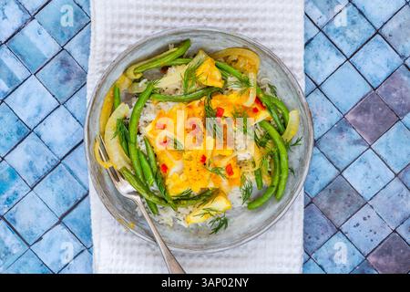 Ginger and turmeric cod with green beans and rice Stock Photo