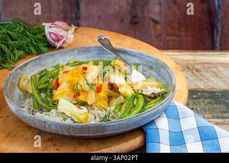 Ginger and turmeric cod with green beans and rice Stock Photo