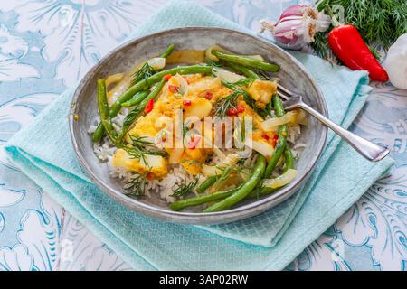 Ginger and turmeric cod with green beans and rice Stock Photo