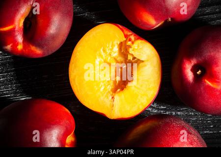 sliced nectarine on black wood background top view Stock Photo