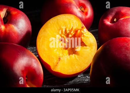 sliced nectarine on black wood background Stock Photo