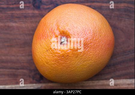 Top view of a whole grapefruit on a wood cutting board Stock Photo