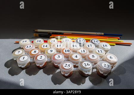 Numbered paint cans and brushes on a gray background. Painting by numbers. Painting set. High quality photo Stock Photo