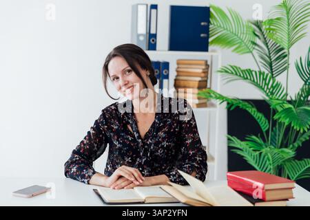 Woman in business suit smiling working at desk in office training Stock Photo