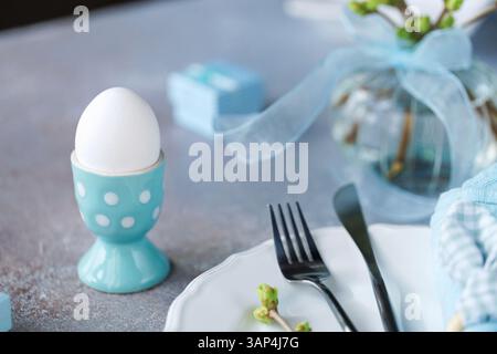 Easter Table Setting with Blue Napkin and Egg Stock Photo