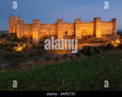 Aerial view of beautiful medieval castle and fort with ancient stone walls at dusk, Banos de la Encina, Jaen, Spain. Stock Photo