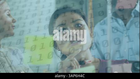 Image of binary coding over diverse business people taking notes Stock Photo
