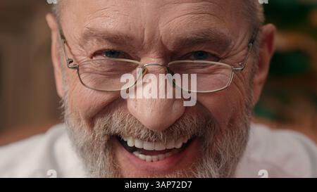 Close up face happy Caucasian European old man elderly wrinkled male expression emotional laugh smile grandfather pensioner businessman investor Stock Photo