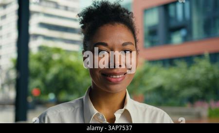 Happy African American woman looking at camera smiling toothy dental smile positive female girl businesswoman outdoor joyful portrait ethnic face Stock Photo