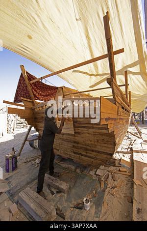 Indian man working at a dhow shipyard in Sur, Janub ash-Sharqiyya province, Oman, Asia Stock Photo