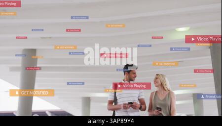 Image of social media icons floating over happy caucasian couple walking and using smartphones Stock Photo