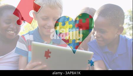 Image of colourful puzzle pieces heart over children using tablet Stock Photo