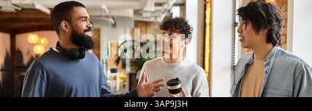 Three professionals share ideas and laughter while enjoying coffee in a vibrant workspace. Stock Photo