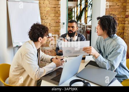 Three professionals collaborate on a project in a stylish office filled with natural light. Stock Photo