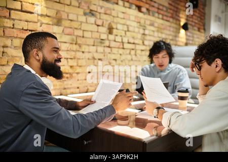 Three professionals engage in a collaborative discussion, reviewing documents and sharing ideas. Stock Photo
