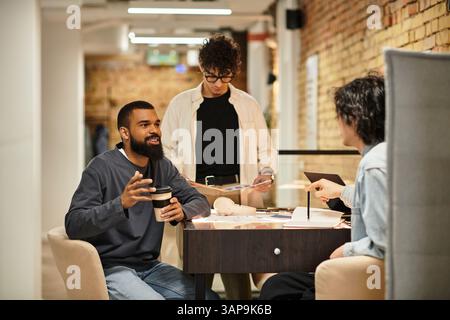Three colleagues chat lively while collaborating on a project in a chic office. Stock Photo