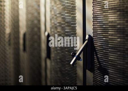 Detailed view of server racks in a modern data center showing advanced technology equipment in a dark environment focusing on metal textures and structures Stock Photo