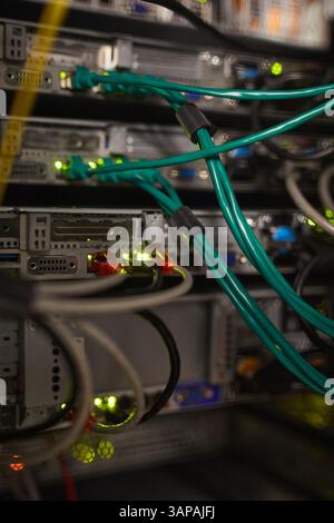 Close-up view of networking cables connecting several servers in an organized data center setup. Various colored cables illustrating complex network infrastructure Stock Photo