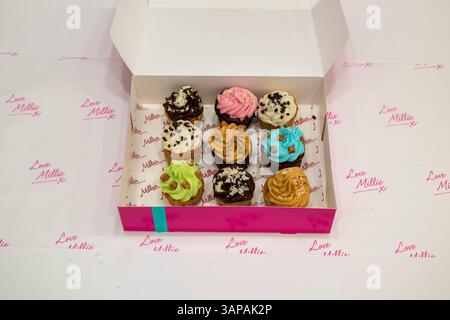 Sheffield, UK – 9 Sept 2019: Selected mini cupcakes decorated with colourful icing from Millie’s Cookies, boxed Stock Photo
