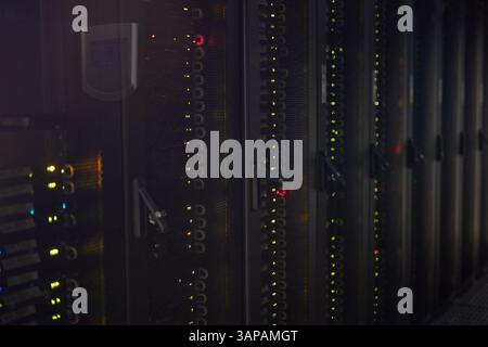 Multiple server racks with illuminated LED lights in data center providing large-scale data processing and storage solutions for businesses and technology companies Stock Photo