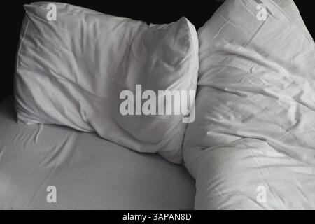 Messy, crumpled, white duvet and pillow Stock Photo