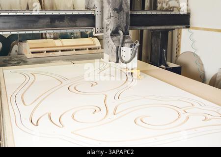 Numerically controlled woodworking machine cuts rounded complex lines on the canvas. Computer numerical control. CNC. Stock Photo