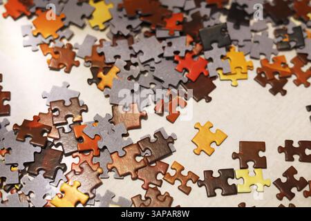 Red, orange, yellow, brown and black jigsaw puzzles scattered on the white surface Stock Photo