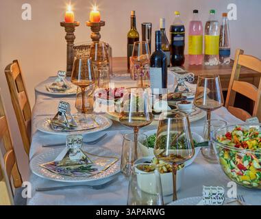 Passover celebration setup with matzah, symbolic herbs, and ceremonial dishes on a beautifully adorned festive seder table. Stock Photo