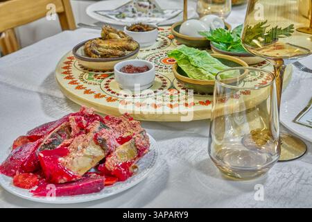 Passover dinner table arranged with matzah, symbolic greens, and a decorated seder plate surrounded by elegant glassware. Stock Photo