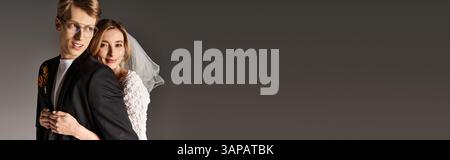 A bride in a white dress and a groom embrace joyfully, celebrating their spring wedding, banner Stock Photo