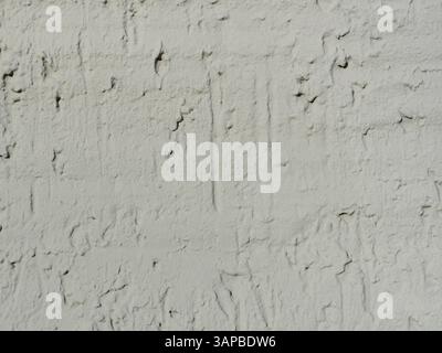 House wall with trowel-applied plaster and a thick gray paint finish. The textured surface gives the facade a striking appearance. Space for text. Stock Photo