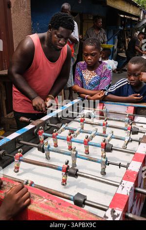 Accra, Ghana. Usshertown. Boys Playing Foosball on Neighborhood Street. Stock Photo