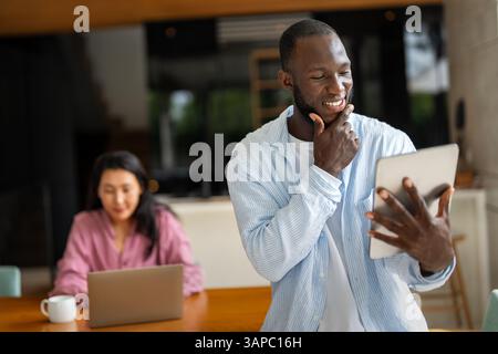 Couple of freelance IT specialists using digital technology devices while working remotely from home Stock Photo