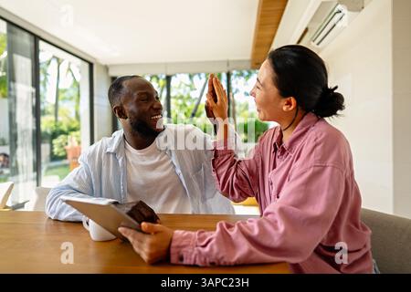 Business team, two happy diverse, multiethnic executives working together using laptop in office. Stock Photo