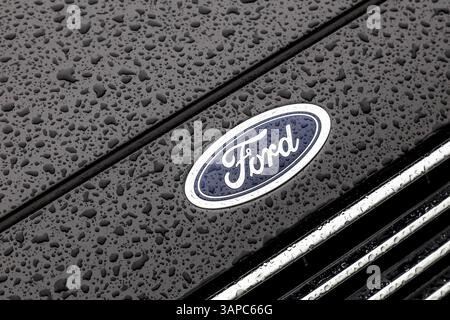 Ford logo on a wet car hood after rain Stock Photo