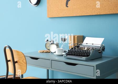 Vintage typewriter with coffee cup, alarm clocks and books on table in office Stock Photo
