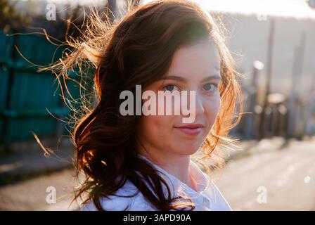 Portrait of a woman smiling in sunlight outdoors. Stock Photo