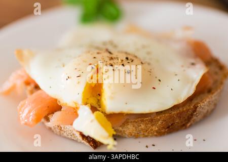 Dietary slice of bread with cooked egg and lightly salted red fish. Stock Photo