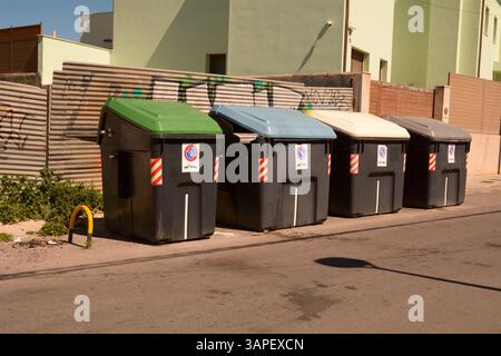 Four recycling bins on the roadside in S'Arenal ,Mallorca, Spain. Green bins are for glass. Blue bins for paper. Yellow bins for plastic. Stock Photo
