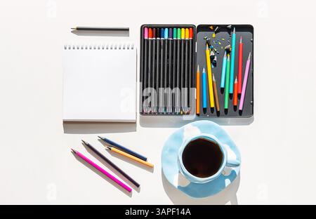 Artistic Workspace Arrangement with Open Colored Pencil Box and Sketchbook in Natural Light. Art Therapy for Relaxation. Stock Photo