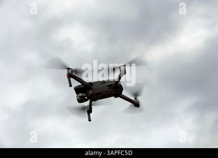 Silhouette of a drone in flight in backlight against the sky, Switzerland Stock Photo