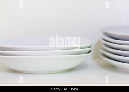 stacked plain white ceramic plates at a house kitchen Stock Photo