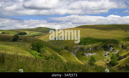 High view of Troller's Gill (remote scenic steep-sided limestone gorge) & sunlit rolling pastures & hills - Skyreholme, Yorkshire Dales, England, UK. Stock Photo