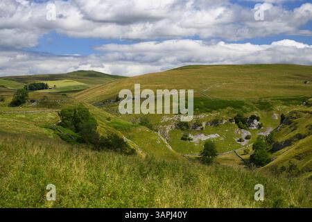 High view of Troller's Gill (remote scenic steep-sided limestone gorge) & sunlit rolling pastures & hills - Skyreholme, Yorkshire Dales, England, UK. Stock Photo