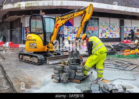Workman working with a Stihl saw on the granite footpath being renovated in Sauchiehall Street, Glasgow, Scotland, UK Stock Photo