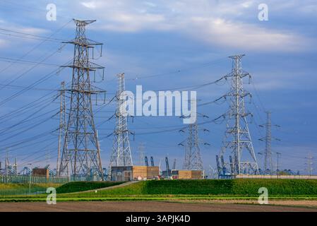 High-voltage electricity pylons / transmission towers and overhead power lines near Doel Nuclear Power Station in Antwerp harbour, Flanders, Belgium Stock Photo