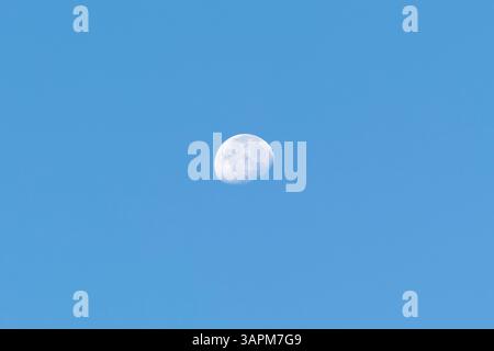Beautiful white waxing cresent moon phase with clear light blue sky at background Stock Photo