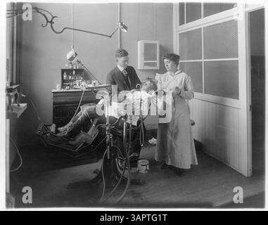 The Blaine School Dentist, shown in an interior setting, provides dental care to students, with a group of children present for the treatment. Stock Photo