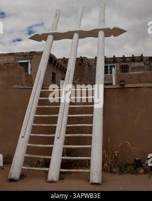 Oct 23, 2010 - Acoma Pueblo, New Mexico, U.S. - A traditional three-pole white wooden kiva ladder provides access to the Acoma Pueblo's ceremonial kiva used for religious ceremonies. Unlike most underground Southwest kivas, Acoma's are above ground, as digging into the mesa's solid rock isn't possible. A Native American pueblo, also known as 'Sky City', it is built on top of a 367-foot (112 m) sandstone mesa. Settled around 1100, it is one of the oldest continuously inhabited communities in the U.S. Located 60 m. (100 km) west of Albuquerque, Acoma Pueblo was named the 28th National Trust for Stock Photo