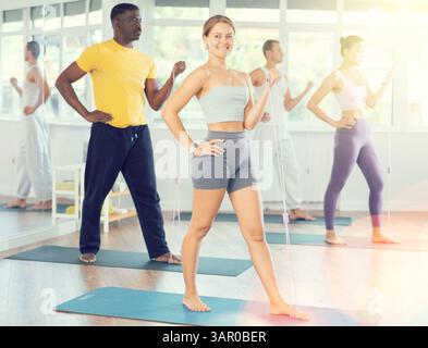 Group of sporty people stretch their arms and legs using an expander Stock Photo